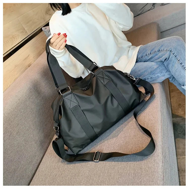 Mulher segurando a bolsa sentada demostrando as alças